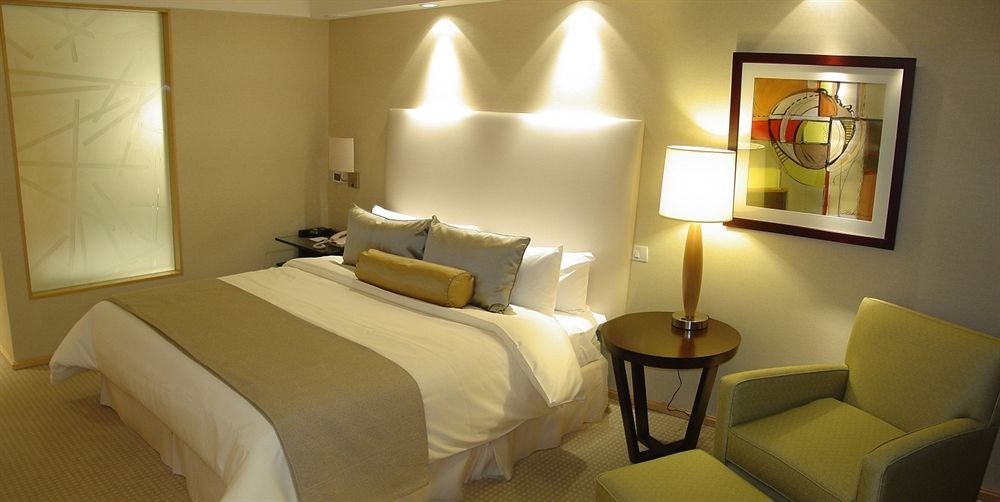 a hotel room with a bed and a lamp