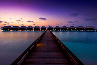 a long dock leading to a row of huts
