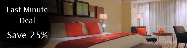a bed with red pillows and a lamp