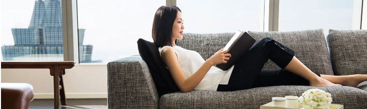 a woman reading a book on a couch