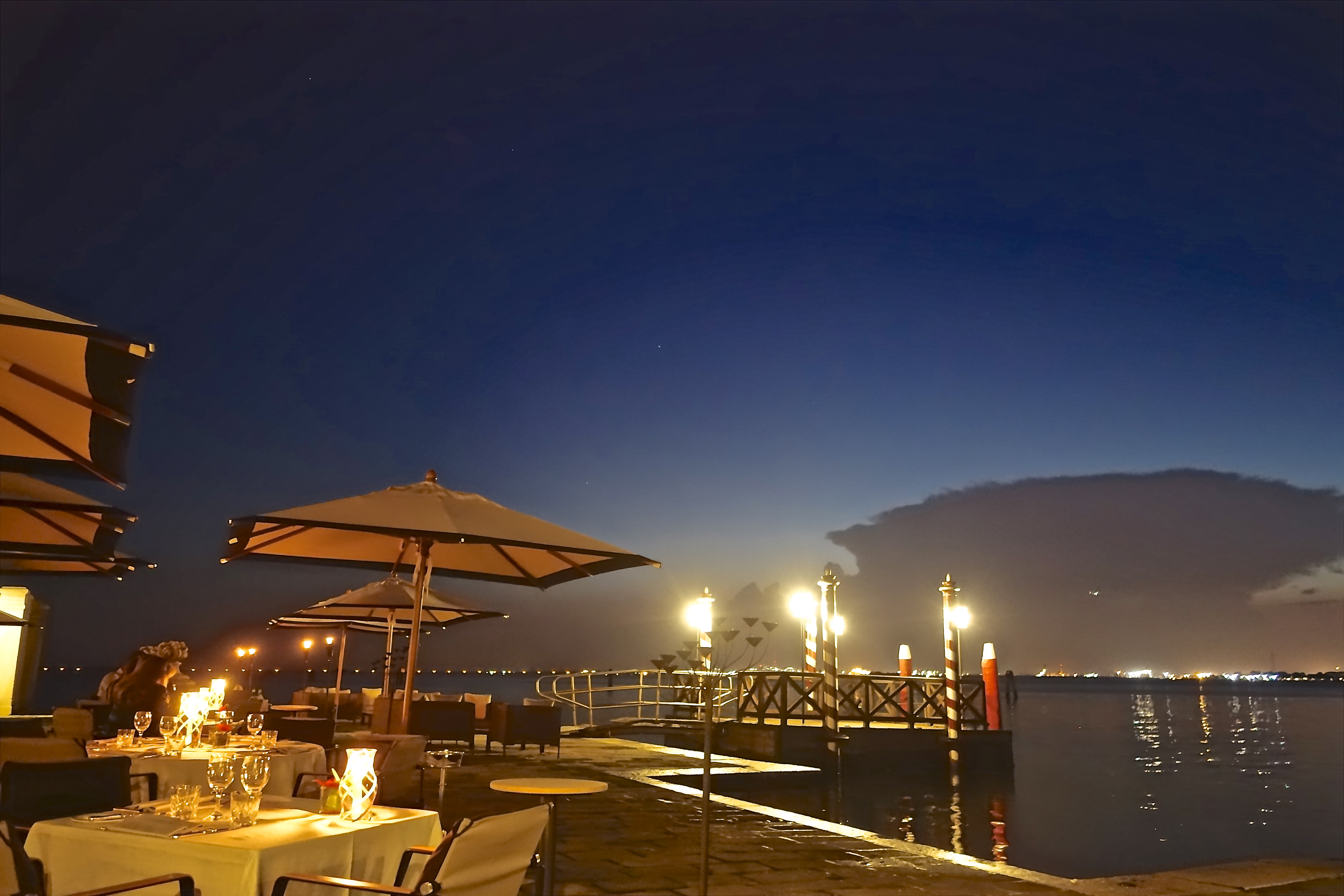 a restaurant on a dock with a pier and lights