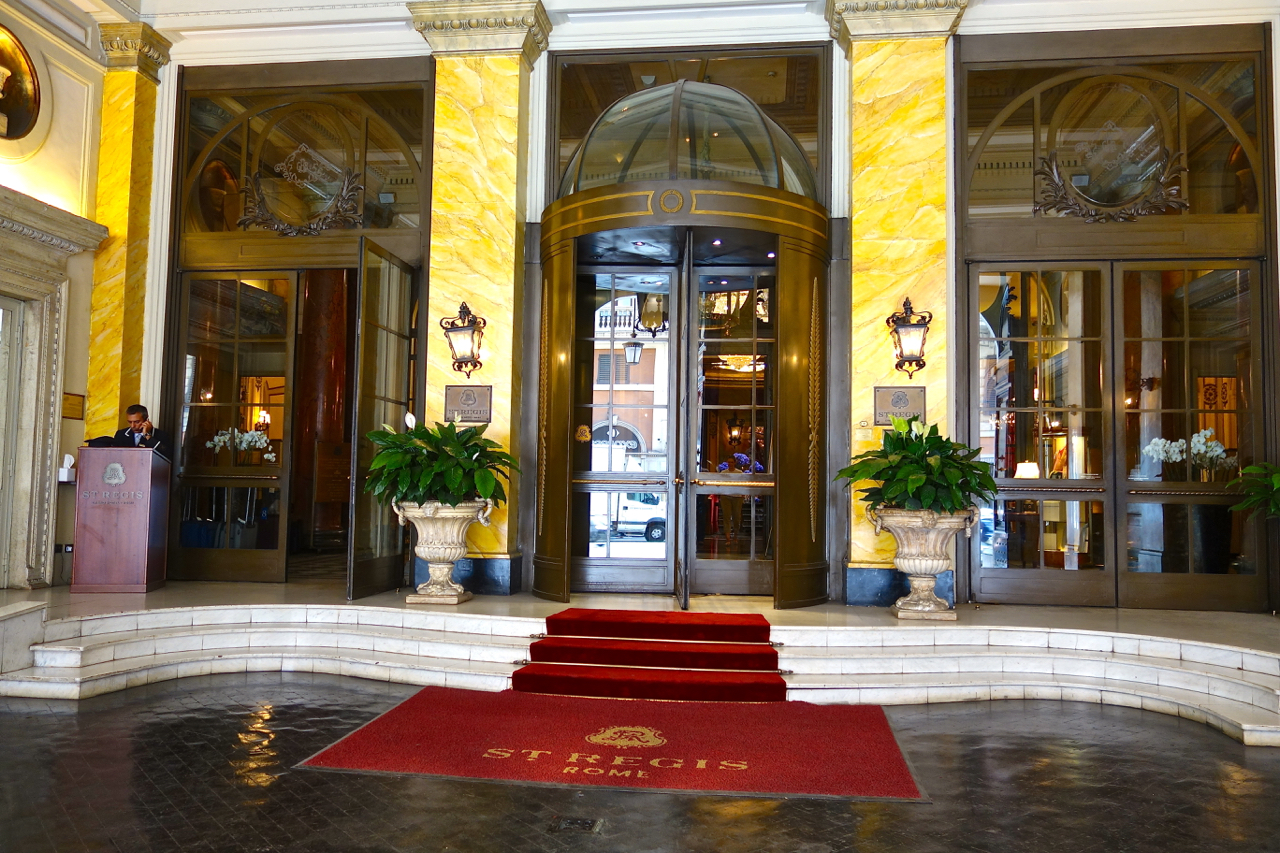 a entrance to a building with a red carpet and plants