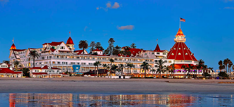 a large white building with red roofs and red roofs on a beach