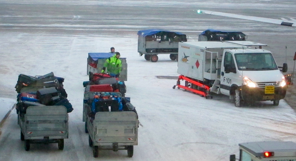 a group of people standing next to luggage carts