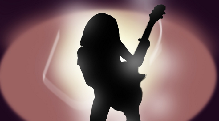 a silhouette of a person playing a guitar