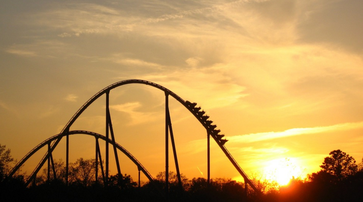 a roller coaster with a sunset in the background