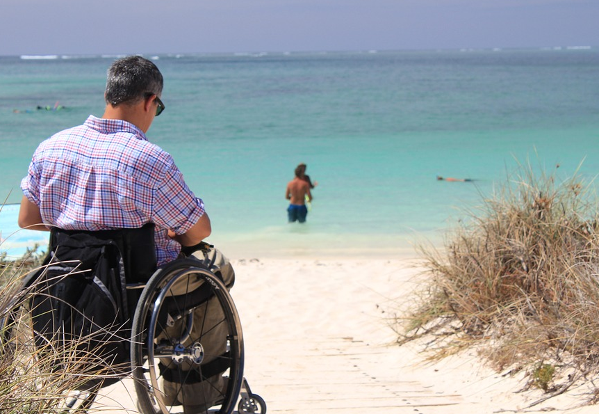 a man in a wheelchair on a beach