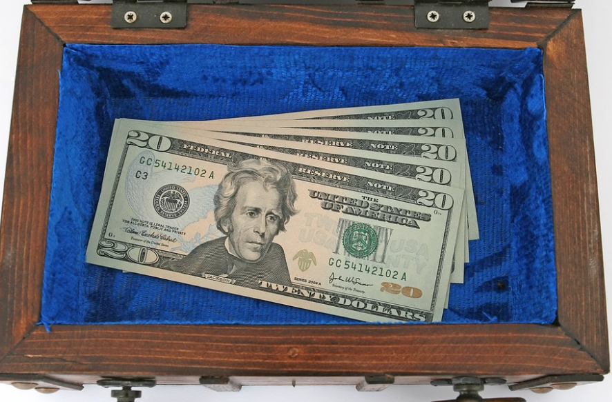 a stack of paper money in a wooden box