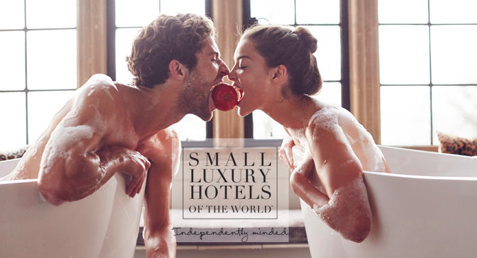 a man and woman in bathtubs biting an apple