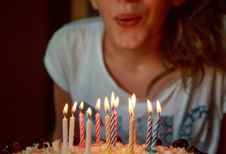 a woman blowing out candles on a cake