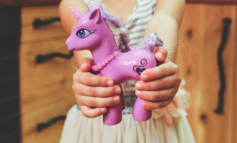 a child holding a toy unicorn