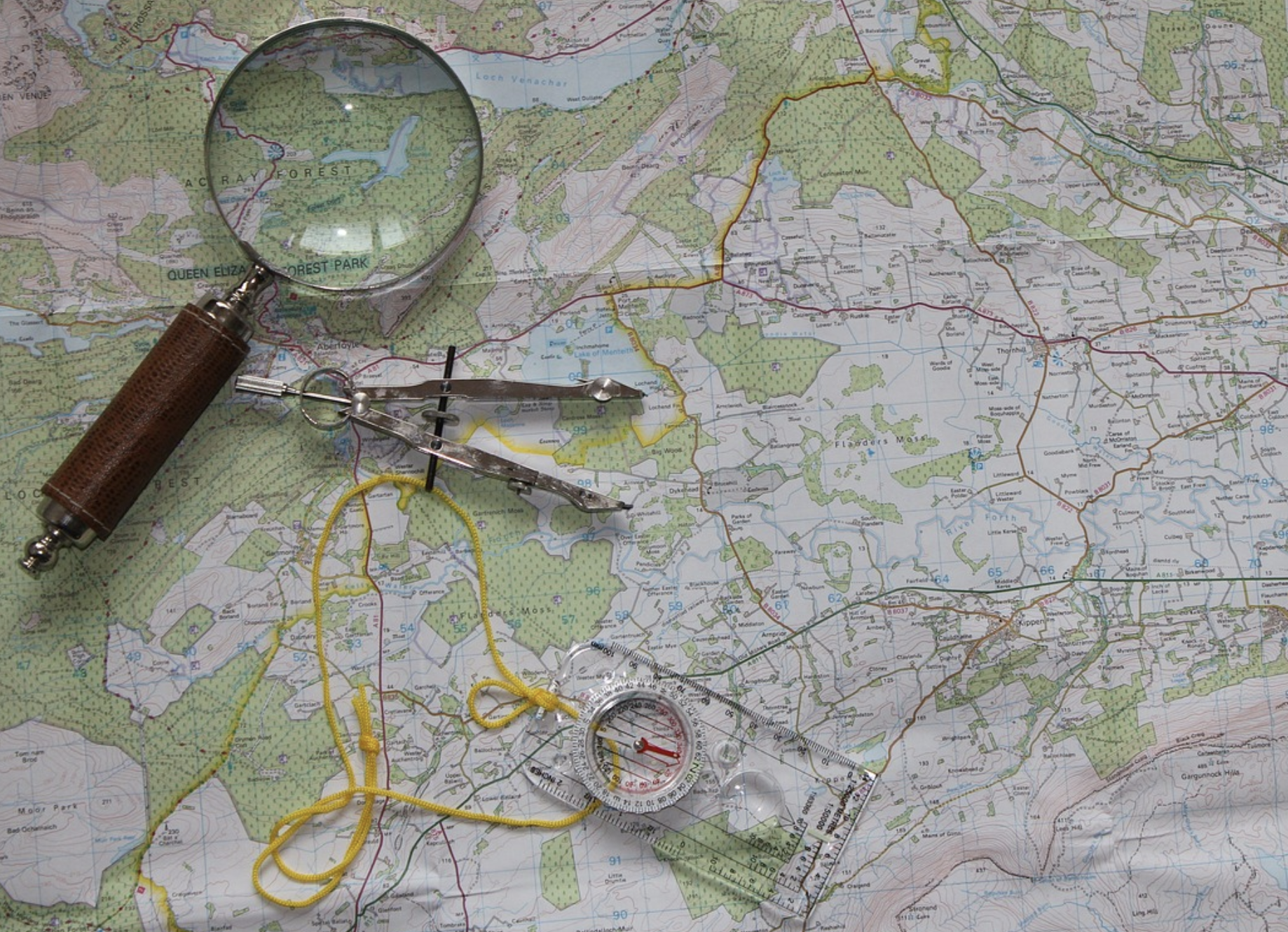 a magnifying glass and compass on a map