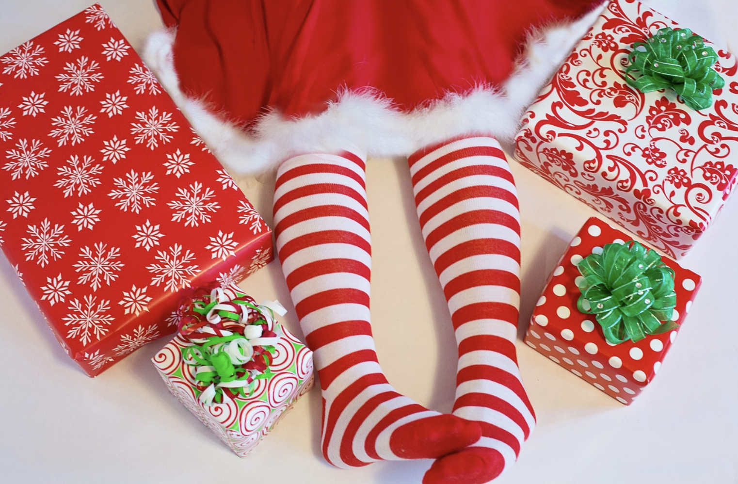a person wearing red and white striped socks and a skirt with presents